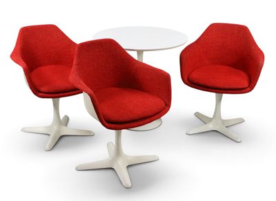 deux chaises rouges et une table blanche posées sur un sol blanc
