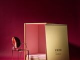 a chair and a box on a pink surface with a pink background