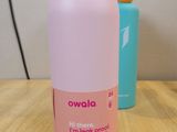 a pink and blue water bottle sitting on a wooden table
