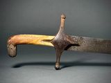 a close up of a knife with a wooden handle