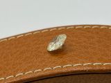 a piece of leather that has a small piece of silver on it