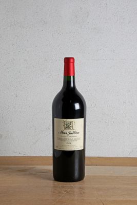 a bottle of red wine sitting on a wooden table