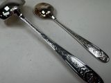 two spoons and a ladle on a table