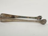 an old silver spoon with a handle sitting on top of a white table