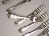 a lot of silver forks and spoons on the table