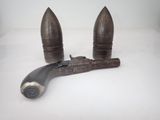 une pipe et un pistolet posés sur une surface blanche