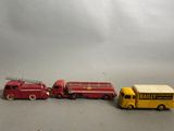 trois camions de pompiers miniatures et un camion de pompiers posés sur une table