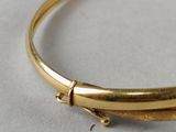 a close up of a gold bracelet with a knot on it