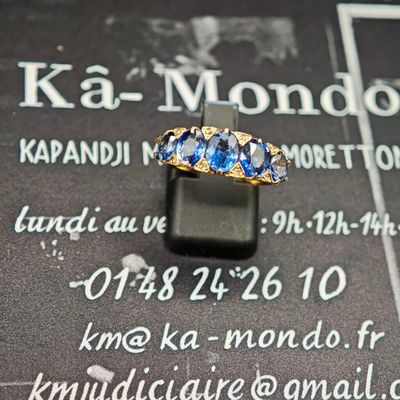 une photo d'une bague en or sertie de pierres bleues
