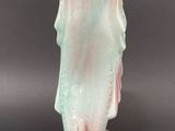 pair of pink and green fish shaped vases sitting on a black surface
