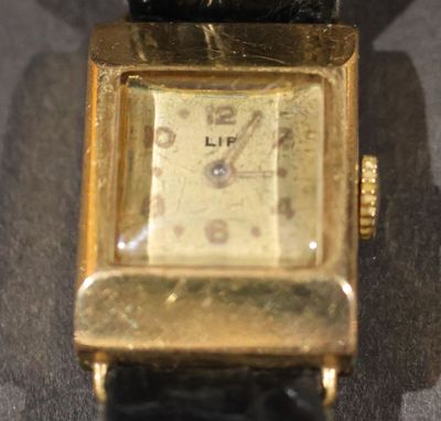 une montre en or posée sur une table noire
