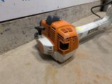 a small blower sitting on the ground next to a wall