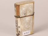 an old lighter with a tag on it sitting on a white surface