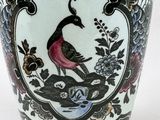 a vase with a bird on it sitting on a table
