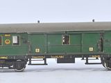 a green train car sitting on the tracks in the snow