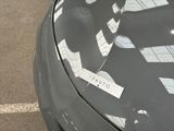 a sticker on the hood of a car that is parked in a parking lot