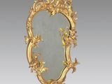 un miroir orné d'un cadre doré, décoré d'oiseaux et de fleurs