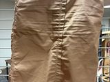 beige skirt hanging on a wire rack in a room
