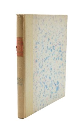un vieux livre posé sur une surface blanche parsemée de taches bleues