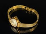 an image of a gold wrist watch on a black surface