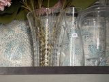 deux vases avec des fleurs posés sur une étagère dans une pièce