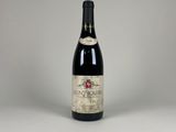 a bottle of red wine sitting on top of a white table