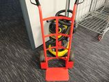 a red hand truck with a hose on it