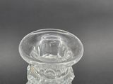 a clear glass candle holder on a black table
