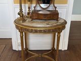 une petite table sur laquelle se trouvent un miroir et une lampe