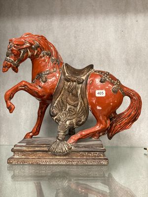 une statue représentant un cheval assis sur une table en verre