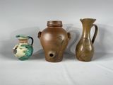 trois vases posés l'un à côté de l'autre sur une surface blanche