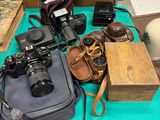 une table bleue sur laquelle se trouvent un appareil photo, un étui à appareil photo et d'autres objets
