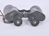 an old pair of binoculars sitting on top of a white surface