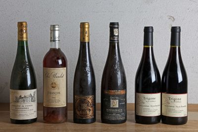 several bottles of wine are lined up on a wooden table