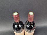 two bottles of wine are sitting on a gray surface