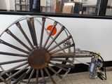 une grande roue métallique posée par terre près d'une fenêtre