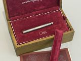 un stylo dans un coffret en bois avec un étui en velours rouge