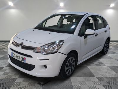la petite voiture blanche est garée sur un sol en damier
