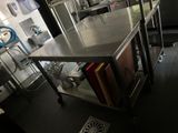 une cuisine avec un grand îlot en inox au milieu de la pièce