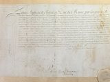 an old document with a wax seal on it sitting on top of a table