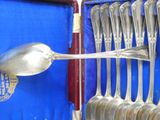 a lot of silver spoons and spoon spoons in a case