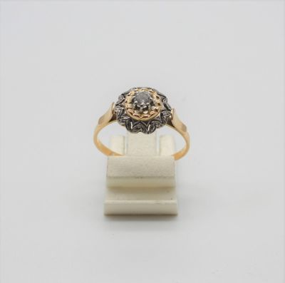 gros plan d'une bague en or et diamants sur une surface blanche