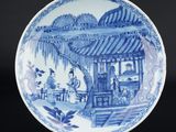 une assiette bleue et blanche ornée d'une scène orientale