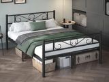 a bed with a metal frame and a green blanket