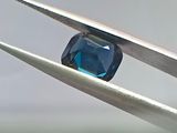 un diamant bleu maintenu par une paire de pinces