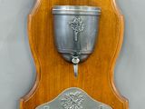 une plaque en bois sur laquelle est posée une coupe en argent