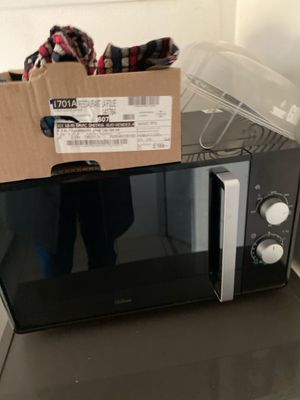 un micro-ondes sur lequel est posé un carton