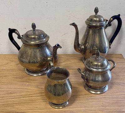 three silver teapots sitting on a wooden table