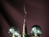 a chandelier with three green glass balls hanging from it
