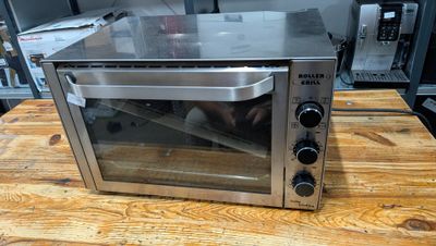 a toaster oven sitting on a wooden table in a kitchen